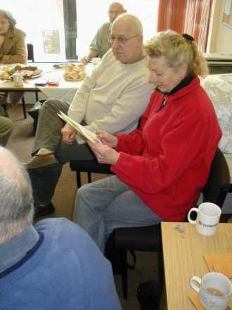 rawmarsh2 Members of the group discussing the proofs of the new book while the digital archive is being displayed.
